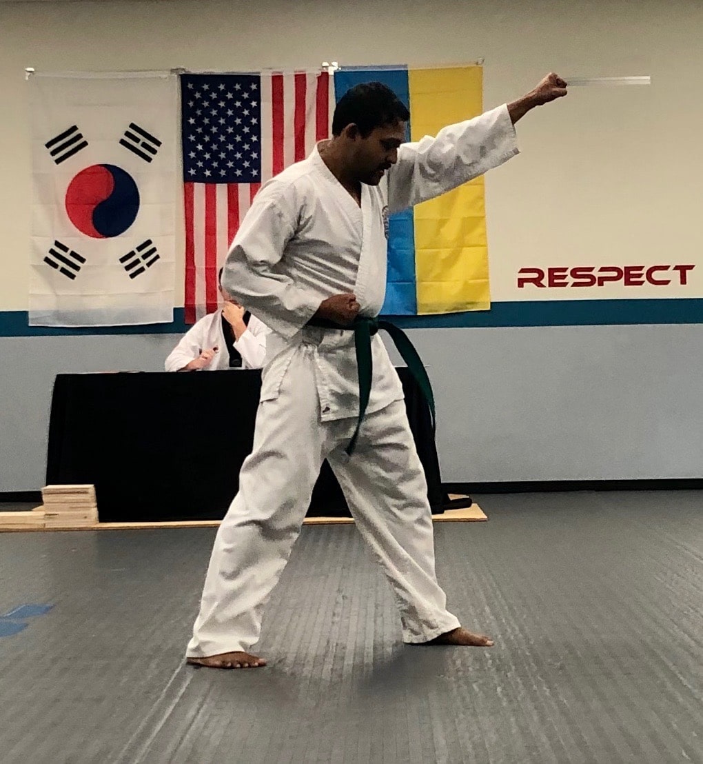 Adult practicing poomsae (Taekwondo forms) during martial arts class